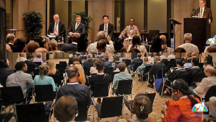 Chair (on podium), four panelists and a section of the audience of the Forum on "A World Free of Nuclear Weapons is Possible" on 11 September 2023 in Berlin held as part of the International Meeting "The Audacity of Peace" hosted by the lay Catholic Association Community of Sant’Egidio. The Forum was co-organized by Soka Gakkai and others. Credit: Sant'Egidio. - Photo: 2023